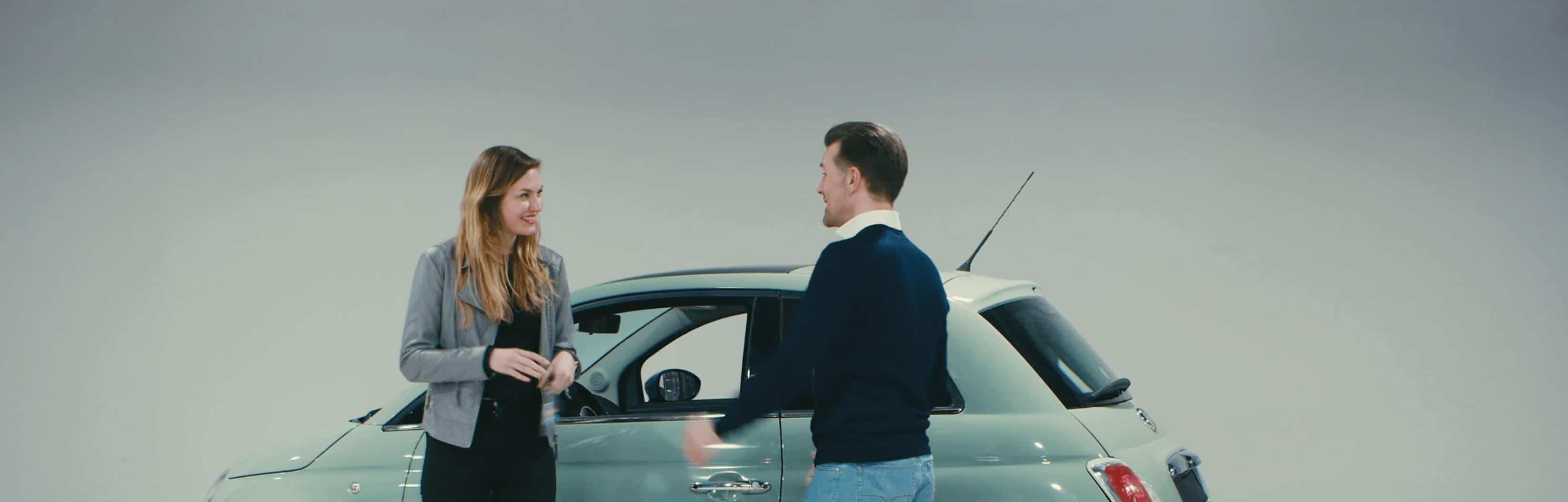 Two people exchanging keys for a car